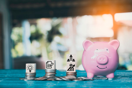 Saving money.Pig piggy bank with icon finance on wood block.They are on blue blackground. save money.investment,bank,finance,Photo financial saving and Saving.の写真素材