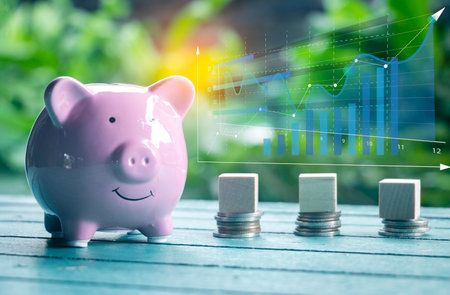Saving  money.Pig piggy bank with icon finance on wood block.They are on blue blackground. save money.investment,bank,finance,Photo financial saving and Saving.の写真素材