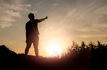 Silhouette man standing and Show hand see sun up.freedom,happy,feel good.Photo concept active and nature background.の写真素材