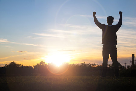 A man raises her hands with sunset.he is so calm hope,respect,spiritual , crucifix,religion and peace.Photo Christian and hope concept idea.の写真素材