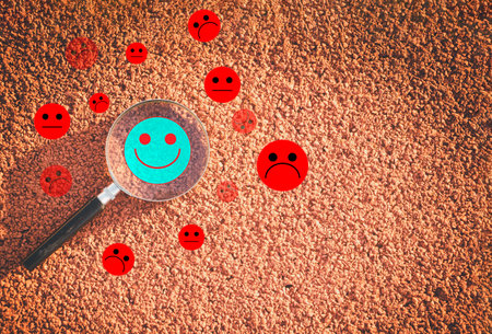 Magnifying glass with smiley face on the ground. Social network conceptの写真素材