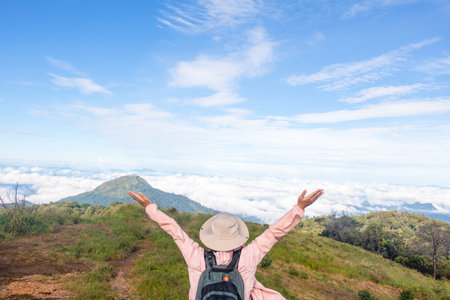 Woman standing on cliff and see over view in nature. Tourist show  hands up and enjoying fresh air. A man enjoying free happiness in beautiful Thailand landscape.の写真素材
