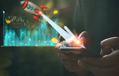 Business man and red rocket flying in space.A man use mobile phone showing hologram stock. fast growing business,save money,investment,bank,finance,Photo financial saving and Startup Concept.の写真素材
