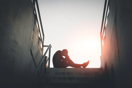 Silhouetted of sad photo. Lonely man sitting on the floor.He is unhappy and sad.He is depression.unlove,unhappy,fail.Photo concept for Disease and depression.の写真素材