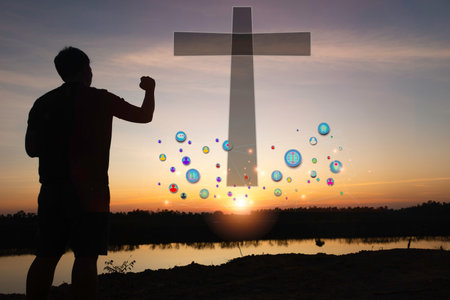 A man raises her hands and cross  with sunset.She is so calm hope,respect,spiritual , crucifix,religion and peace.Photo Christian and hope concept idea.の写真素材