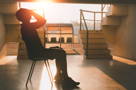 Silhouetted of sad photo. Lonely man sitting on the floor.He is unhappy and sad.He is depression.unlove,unhappy,fail.Photo concept for Disease and depression.の写真素材
