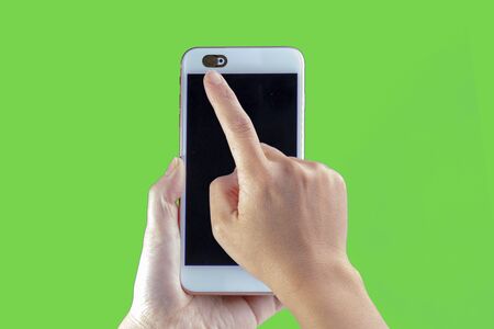Camera privacy cover slide, for front camera cover for smart device hand hold on a green backgroundの写真素材
