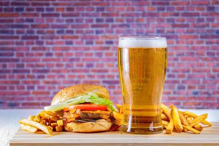 Glass of beer and fries on wooden tableの写真素材