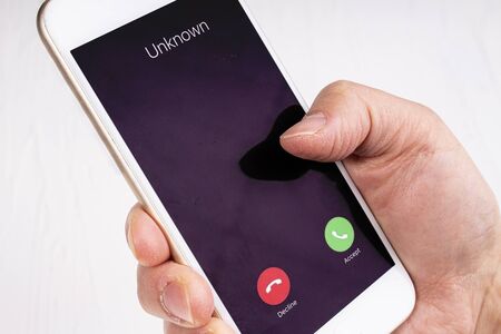 Unknown call on a mobile phone, holding deviceの写真素材