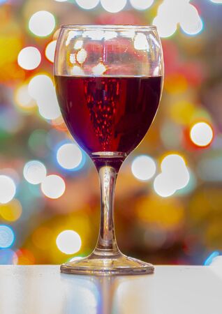 A Cup of wine with Christmas lights on the Background. Vertical viewの写真素材