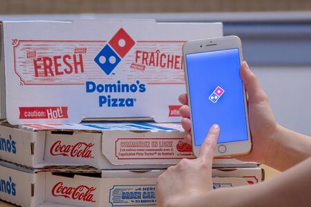 Calgary, Alberta. Canada Dec 26, 2019. Close up of a person using the Dominoâ€™s Pizza...