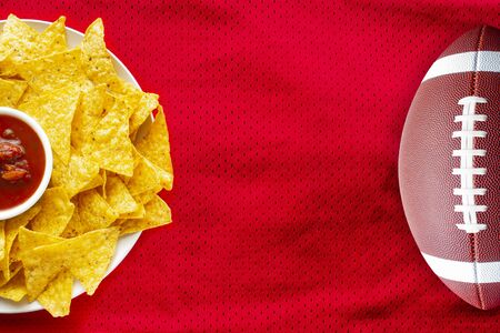 American Football Jersey textured with a football and nachos with a salsa dip on a horizontal viewの写真素材