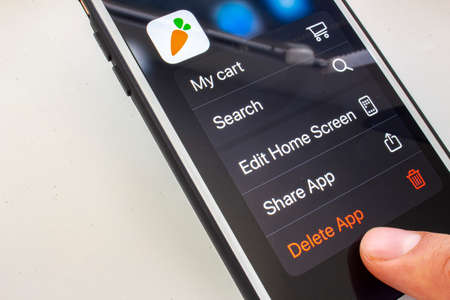 Calgary, Alberta. Canada. April 11, 2020. A person about to delete the Instacart application on a...