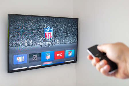 Calgary, AB, Canada. June 11, 2020. A person using an apple tv remote using the NFL application. Concept watching American Football.のeditorial素材