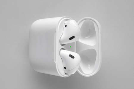 Calgary, Alberta, Canada. Aug 2, 2020. Close up of Apple AirPods with Wireless Charging Case on a...