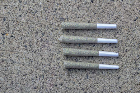 Pre-Rolls Cannabis Joints and dried flower marijuana on a concrete backgroundの写真素材