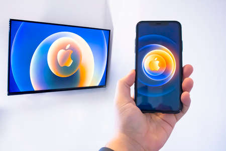Calgary, Alberta, Canada. Oct 13, 2020. A person watching an apple event on the TV and an iPhone.