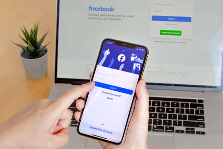 Calgary, Alberta. Canada. Nov 11 2020: A close up of a person using Facebook app on an iPhone Pro 12...