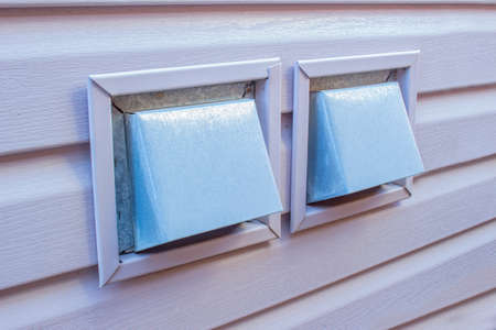 Side view of an Air Wall Cap. Vent cap outside building. Furnace duct outside of a residencial house