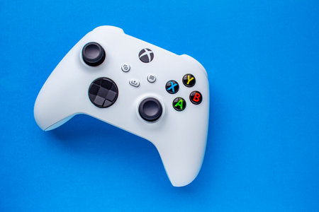Calgary, Alberta, Canada. Jan 06, 2021. A White Xbox Wireless Controller, Robot White. Compatible Xbox Series X|S, Xbox One on a blue background.のeditorial素材