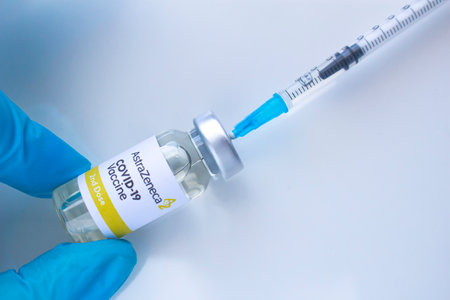 Calgary, Alberta. Canada. Jan 20, 2021. A health worker with a Astra Zeneca Covid-19 vaccine and a syringe on a white backgroundのeditorial素材