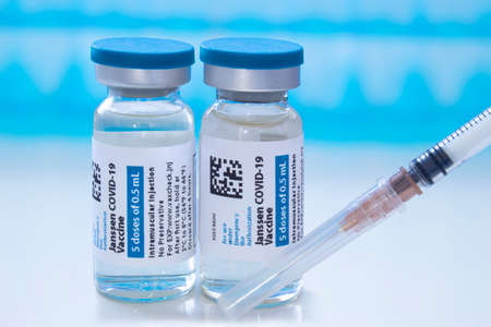 Calgary, Alberta, Canada. April 8, 2021. A couple of Janssen Johnson & Johnson dosis of Covid-19 vaccines on vial bottles and an injection syringe.のeditorial素材