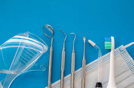 Dentist tools on blue surface close up. Professional Dental Hygiene cleaning tools. Calculus and...
