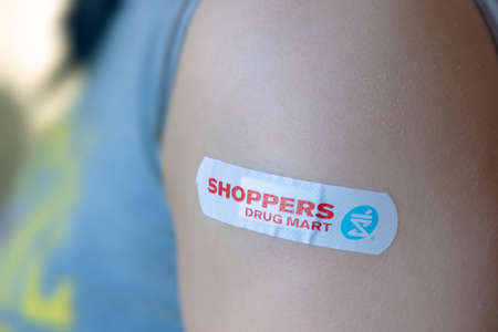 Calgary, Alberta, Canada. Nov 6, 2021. An Adult female with a Vaccine Shoppers Drug Mart Adhesive...