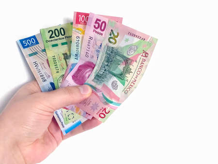 CancÃºn, Quintana Roo, Mexico. Dec 30, 2021. A person holding Mexican banknotes bills currency on a clear background.の写真素材