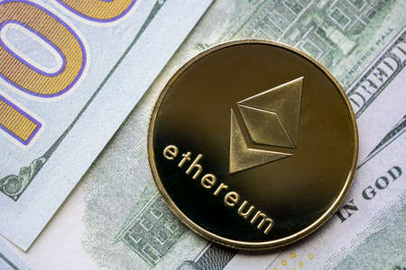 Calgary, AB. Canada. Feb 22, 2022. A Ethereum coin with American Money on the background. A...