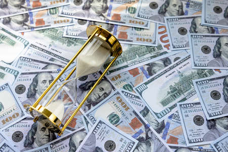 Sand Timer Clock with Sparkling White Sand and American Banknotes. Concept: Time for Savingの写真素材