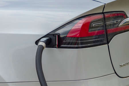 Calgary, Alberta, Canada. Jun 2022. A close up to a Tesla Supercharger stall with charging cable-outlet charging an electric car. 480 volt Supercharging or DC fast charging.のeditorial素材