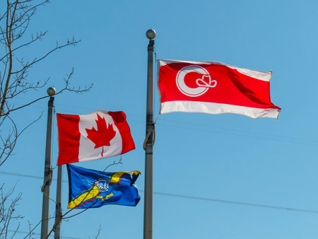 Calgary, Alberta, Canada. Apr 30, 2023. A Calgary flag next to a Canada flag with a Calgary Fire Department flag.のeditorial素材