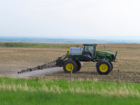 Calgary, Alberta, Canada. Jun 4, 2023. A farmer driving a tractor applying pesticide to destroy or control weeds and other unwanted vegetation.のeditorial素材