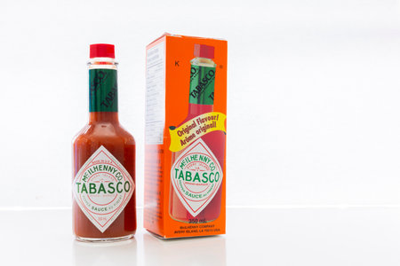 An isolated pepper sauce Tabasco bottle with a box package. An American brand of hot sauce made from tabasco peppers, vinegar and salt.のeditorial素材