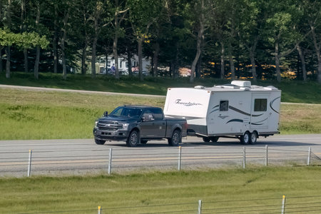 Calgary, Alberta, Canada. Aug 1, 2023. A truck towing a camper RV trailer on the highway.のeditorial素材