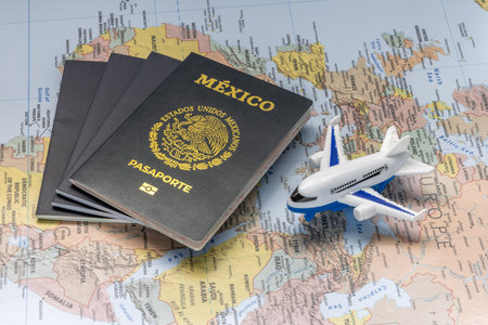 Mexico City, Mexico. Aug 3, 2023. Mexican passport next to an airplane on a world map. Concept: Mexicans traveling abroad.のeditorial素材