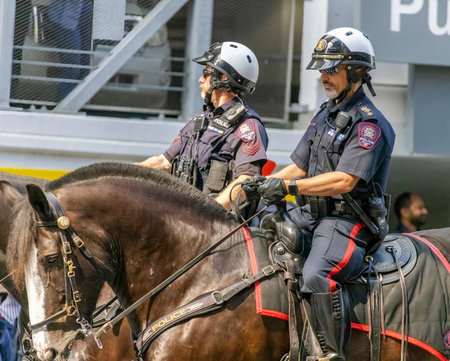 Calgary, Alberta, Canada. July 7, 2023. A close up to couple of police officers riding horses wearing helmets at a public parade.のeditorial素材