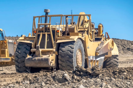 Cochrane, AB, Canada. Aug 13 ,2023. A Close up to a twin engine scrapers on a construction site during the summer.のeditorial素材