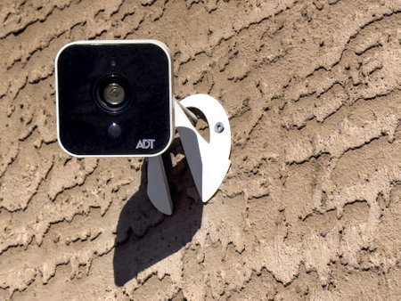 Calgary, Alberta, Canada. Oct 15, 2023. An ADT security camera mount on a wall outdoors.のeditorial素材