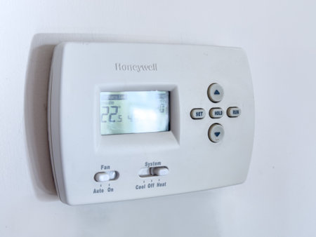 Calgary, Alberta, Canada. Oct 15, 2023. A Honeywell thermostat on a clear wall.のeditorial素材