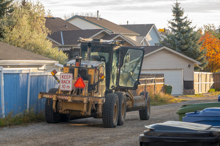 Calgary, Alberta, Canada. Oct 10, 2023. A Caterpillar Cat Motor Grader used to maintain gravel back lanes, enhancing mobility and conditions for residents. Back Lane Gravel Repair Program.のeditorial素材