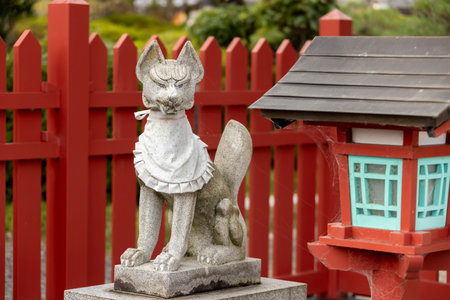Nagahama, Shiga Prefecture, Japan. Nov 21, 2023. A stone statue of a fox Inari Åkami spirit god of Japan. Statue of a kitsune adorned with a white votive bib in a shrine.のeditorial素材