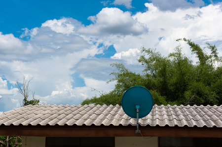 Green Satellite dish on the roof with a beautiful blue sky.の写真素材