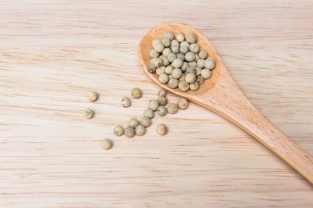 Pepper in wooden spoon on a wooden backgroundの写真素材