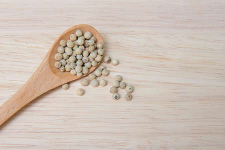 Pepper in wooden spoon on a wooden backgroundの写真素材
