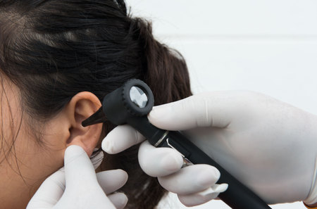 woman doctor monitors the patient's ear with equipmentの写真素材