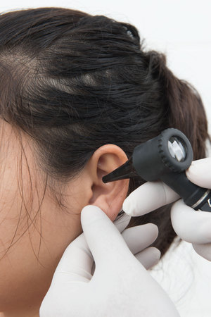 woman doctor monitors the patient's ear with equipmentの写真素材