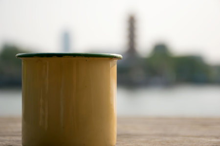 Close up Yellow cup on a wooden table next to the river.の写真素材