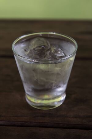 Cold water in a glass on a wooden table.の写真素材
